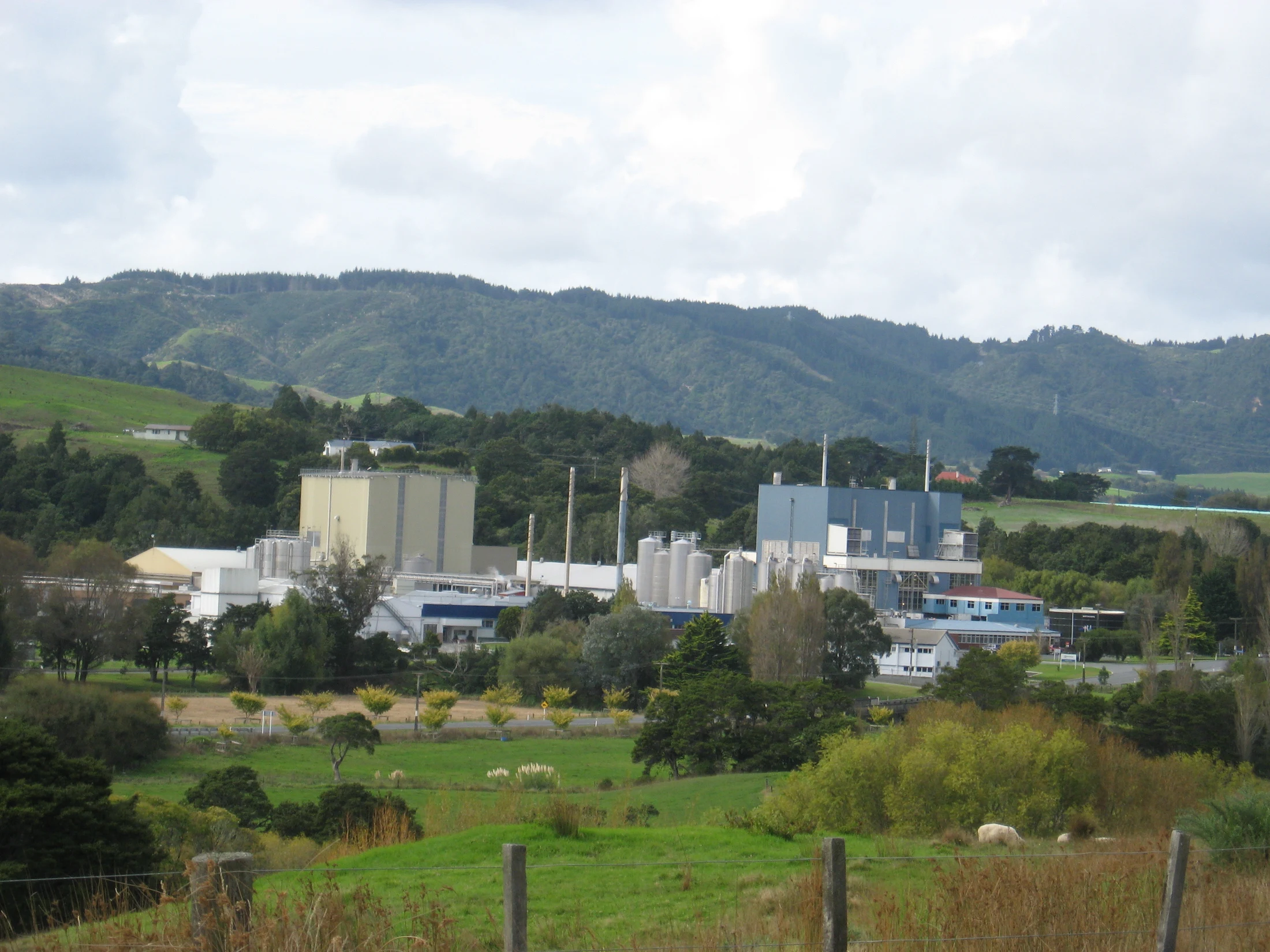 Distant food or dairy plant view with storage tanks; no clear wastewater-treatment unit is visible